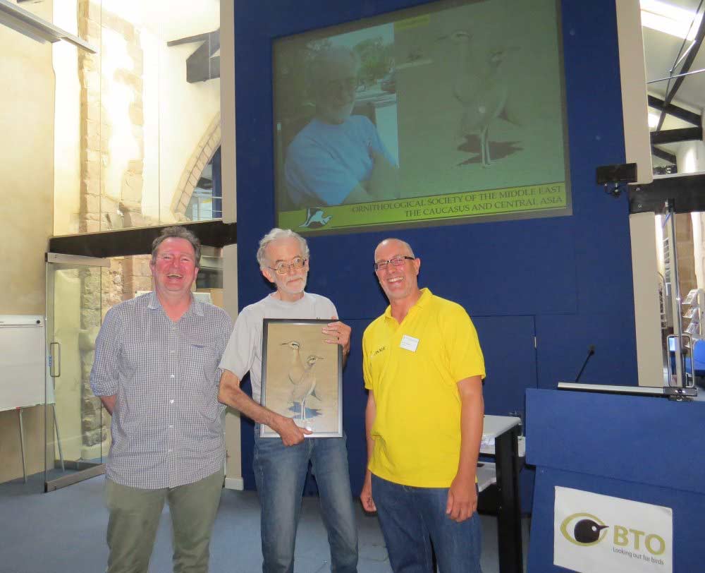 Plate 6. Peter Cowan receives a framed picture of his favourite Sandgrouse front cover.